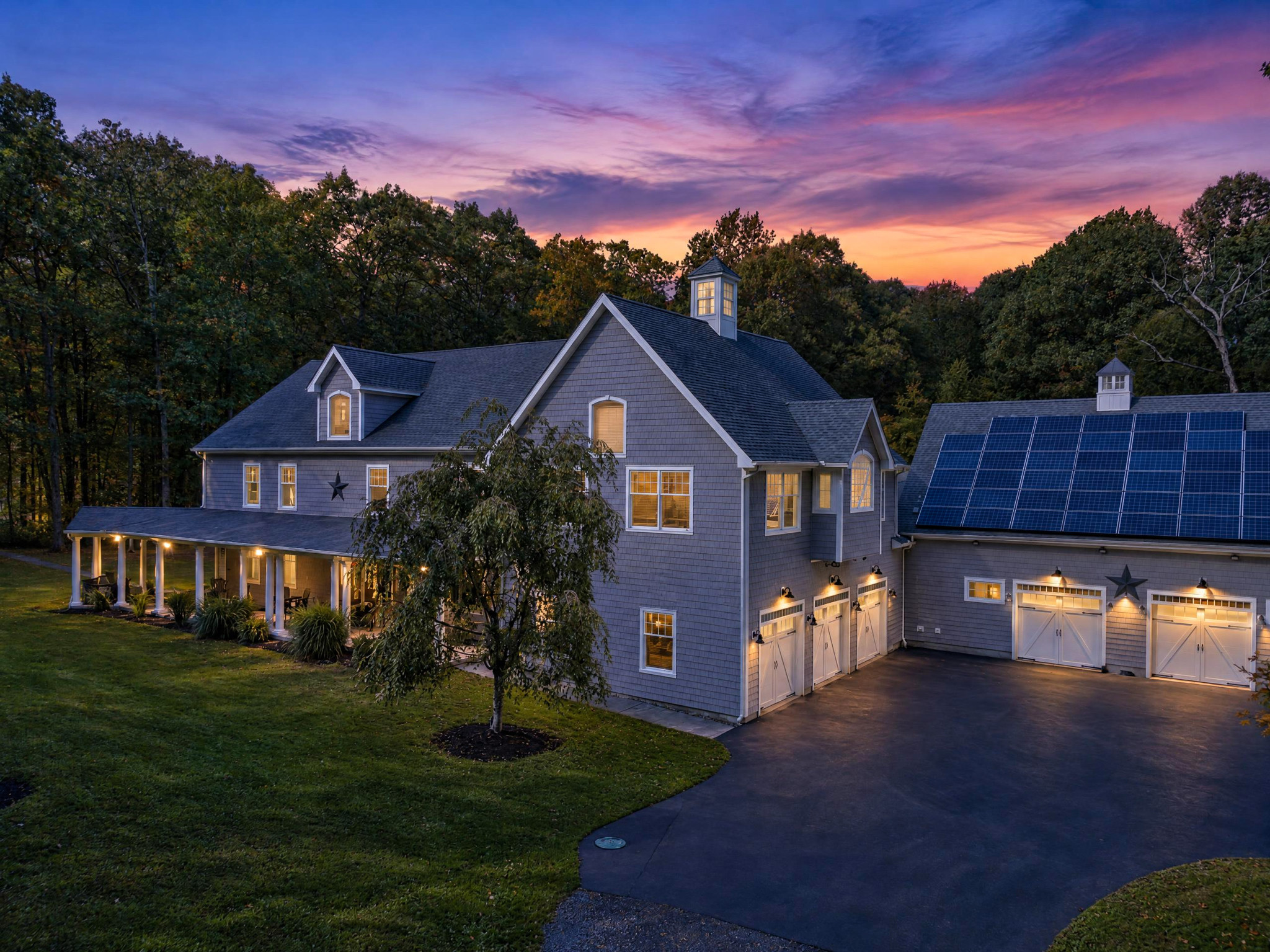 Digitally enhanced twilight version showing a sunset sky and illuminated house windows.