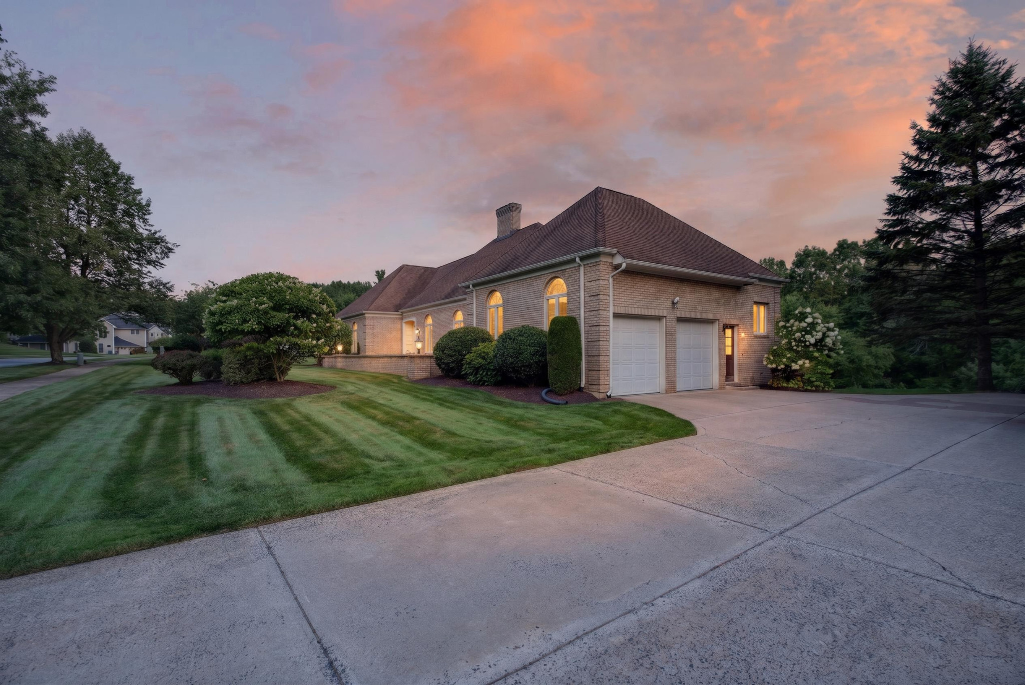 Exterior house photograph with illuminated windows and a colorful evening sky.