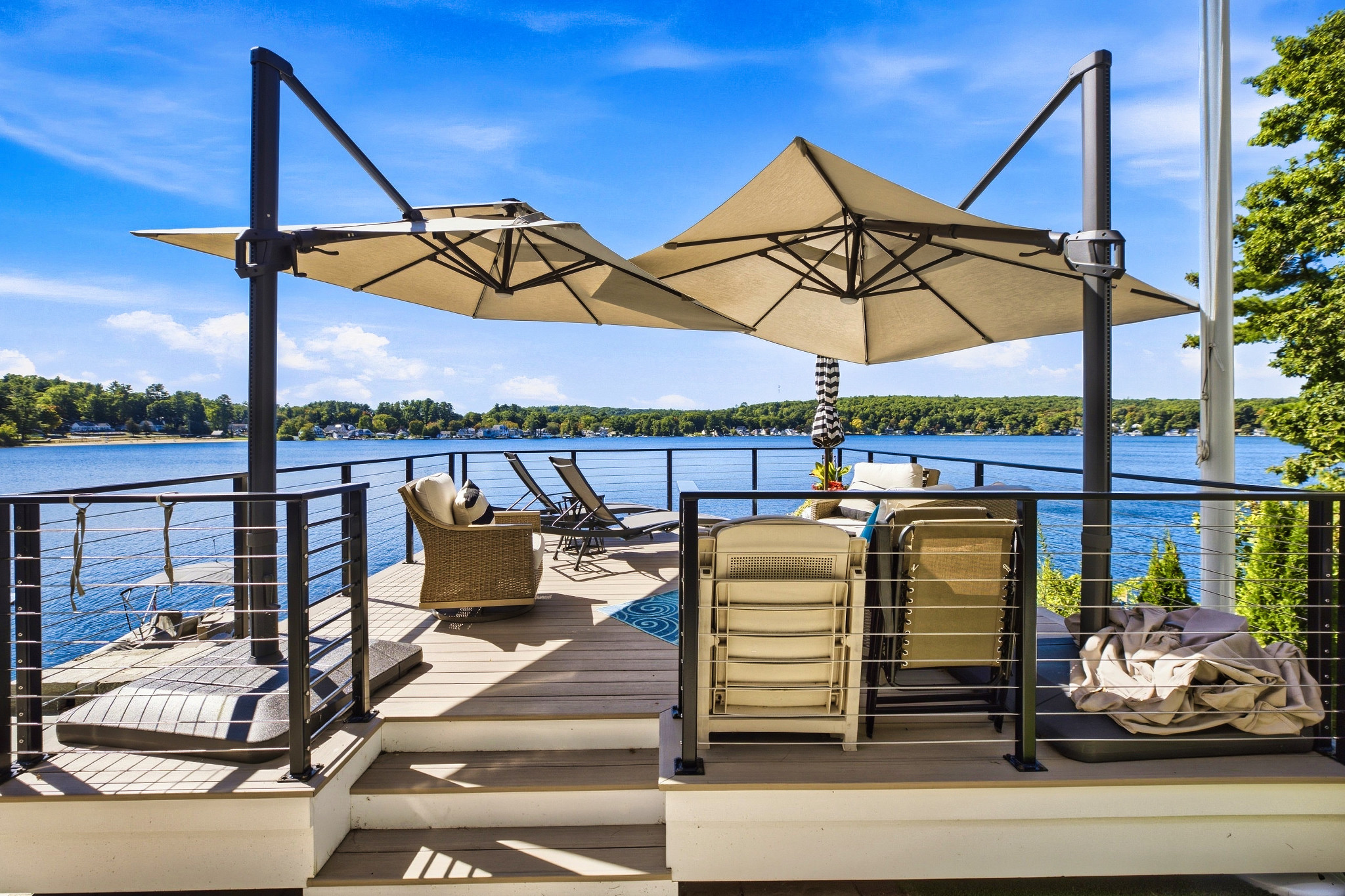 Lakeside deck with seating and umbrellas overlooking the water.
