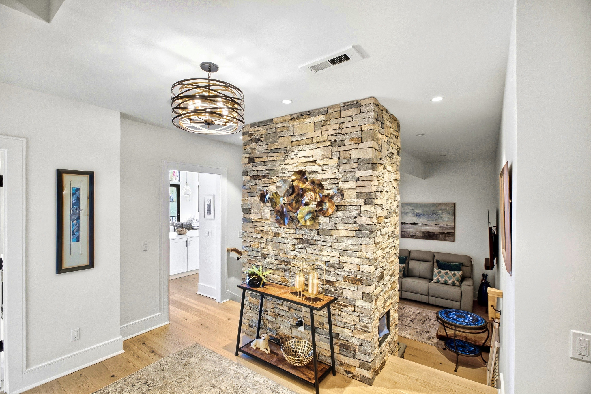 Stone fireplace feature with adjoining light-filled interior spaces.